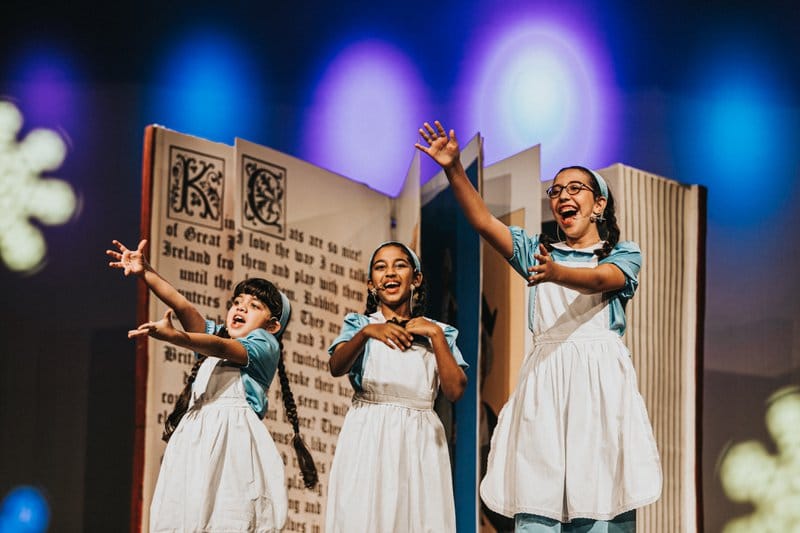 3 girls sing on stage