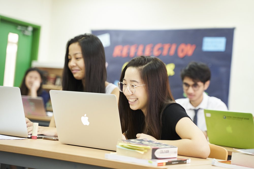 female student looking at laptop and laughing